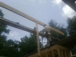 Carpenter setting a ridge beam over a new addition frame — Ice Dam Removal by Roofing Brothers in Bardstown