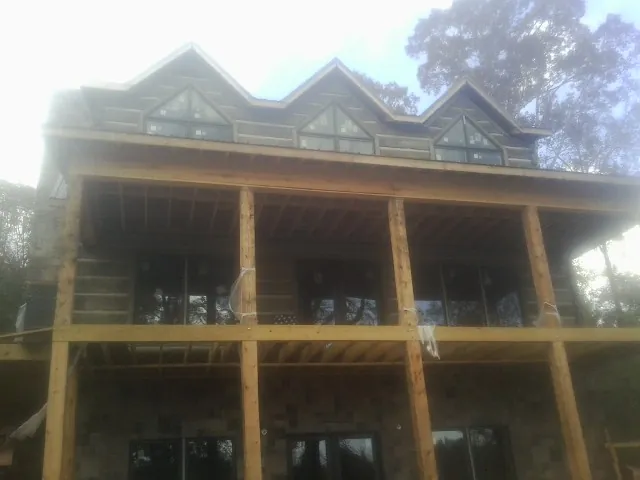 Dormers and porch framing on a large log home under construction — Roof Coating work by our crew in Bardstown