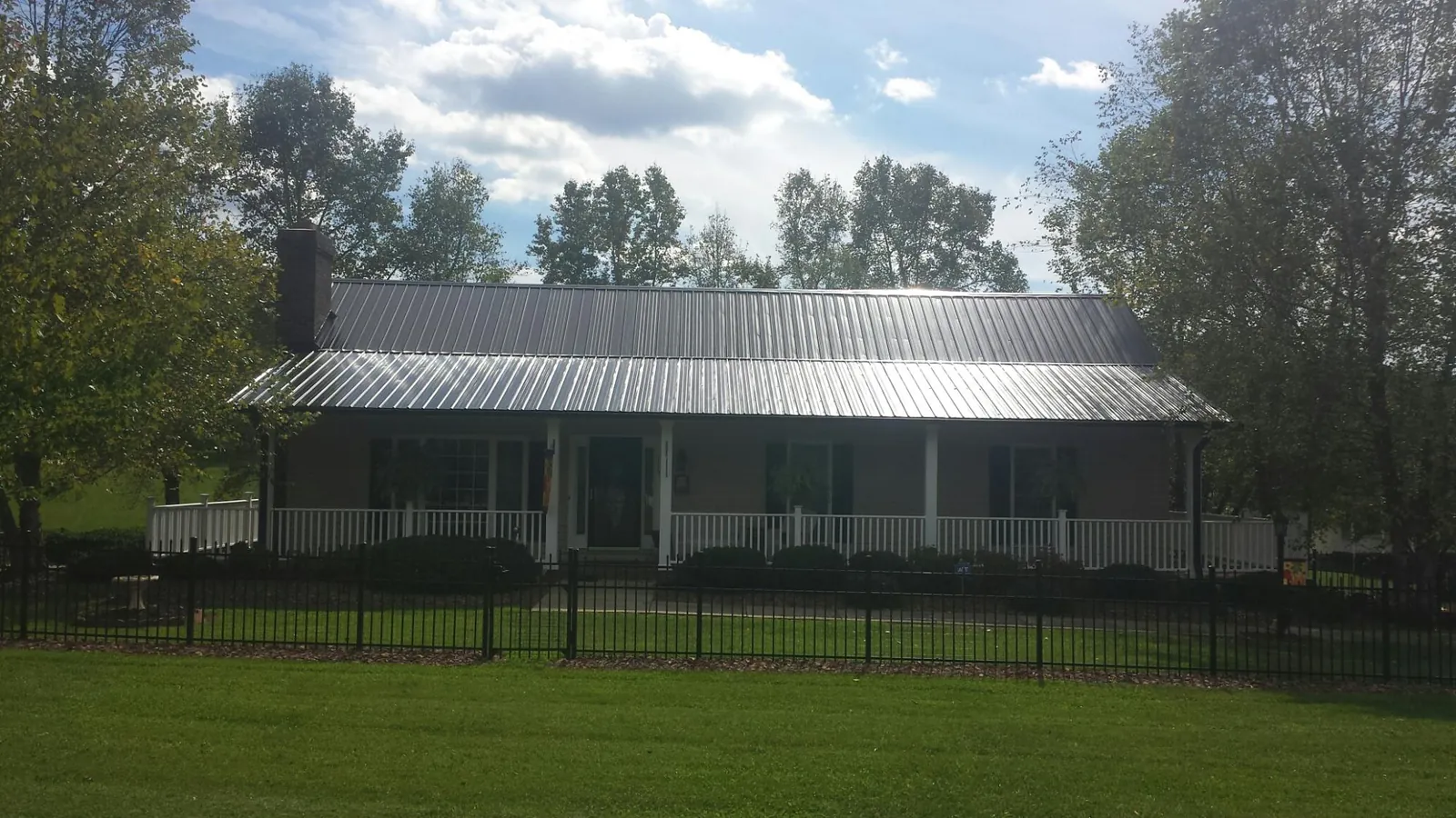 Gray metal roof on a brick ranch with a full width front porch — Gutter Guard Installation work by our crew in Bardstown